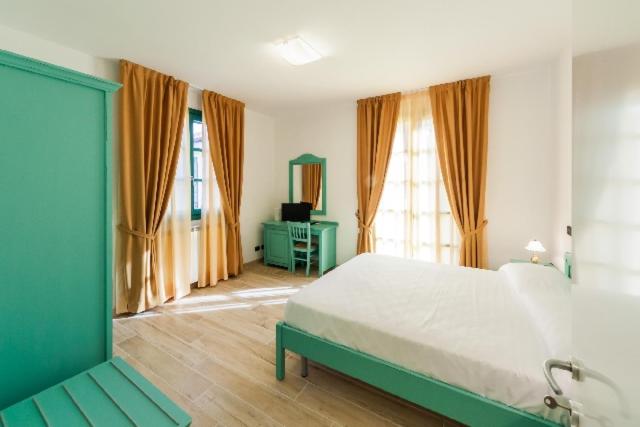 Agriturismo Le Meridiane — helles Zimmer mit Doppelbett